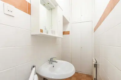 a white bathroom with a sink and a mirror at Riari 59 Rome Trastevere - Rome Vacation M&D in Rome