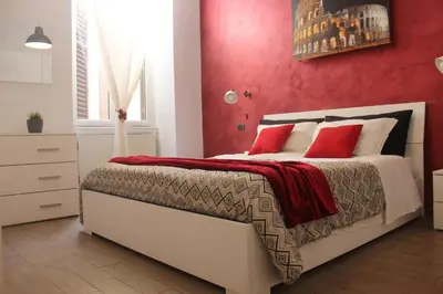 a bedroom with a white bed with red walls at Riari 59 Rome Trastevere - Rome Vacation M&D in Rome