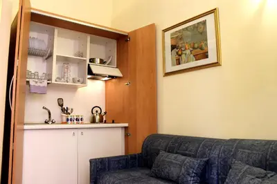 a living room with a couch and a kitchen at Aida Trevi Fountain Rome in Rome