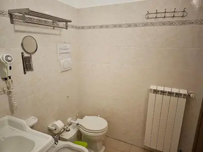 a small bathroom with a toilet and a sink at Aida Trevi Fountain Rome in Rome