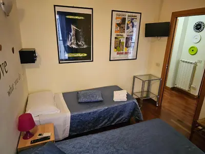 a small room with a bed and a table with a lamp at Aida Trevi Fountain Rome in Rome