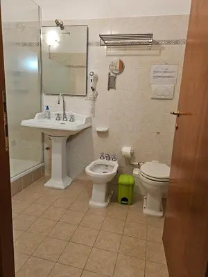 a bathroom with a sink and a toilet and a mirror at Aida Trevi Fountain Rome in Rome