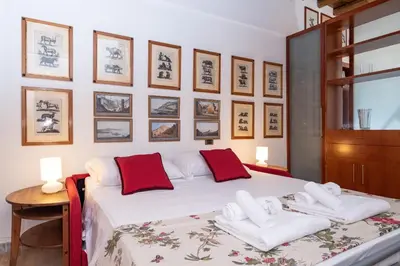 a bedroom with a large white bed with red pillows at Campo de' Fiori Cozy Nest in Rome