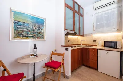 a small kitchen with a table and a small table with a wine bottle at Campo de' Fiori Cozy Nest in Rome