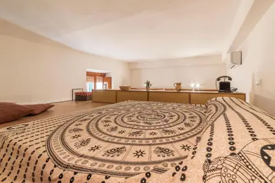 a bedroom with a large bed with a rug on it at GuestHost - Lovely Loft Trastevere in Rome