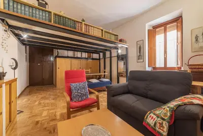 a living room with a couch and a chair at GuestHost - Lovely Loft Trastevere in Rome
