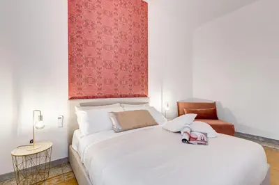 a bedroom with a white bed with a red wall at BDC - Termini Sun Apartment in Rome