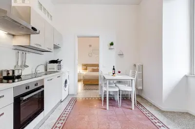 a white kitchen with a table and chairs in it at BDC - Termini Sun Apartment in Rome