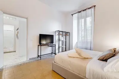a white bedroom with a bed and a television at BDC - Termini Sun Apartment in Rome