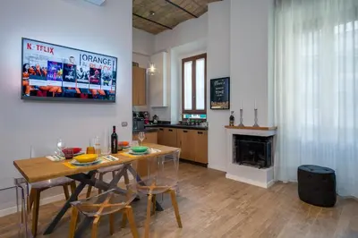 a kitchen and dining room with a table and a fireplace at One & Only Buonarroti Suite in Rome