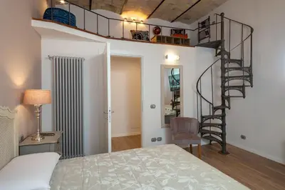 a bedroom with a bed and a spiral staircase at One & Only Buonarroti Suite in Rome