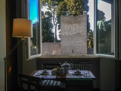 a table in front of a window with a table and a lamp at LUMINOSA VISTA PIRAMIDE in Rome