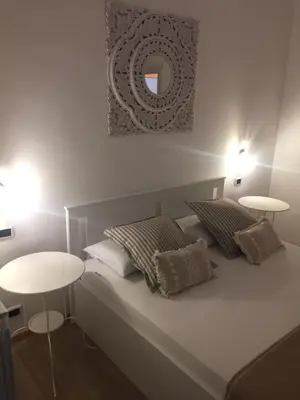 a bedroom with a bed with two tables and a mirror at Appartamento vicino Stazione Termini e Colosseo in Rome