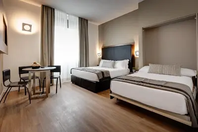 a hotel room with two beds and a table at Rome Art Hotel - Gruppo Trevi Hotels in Rome