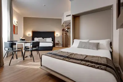 a bedroom with a bed and a table with chairs at Rome Art Hotel - Gruppo Trevi Hotels in Rome