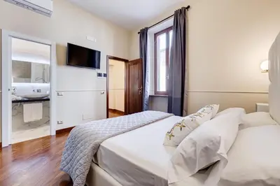 a bedroom with two beds and a bathroom with a sink at Trevi Private Suites by Premium Suites Collection in Rome