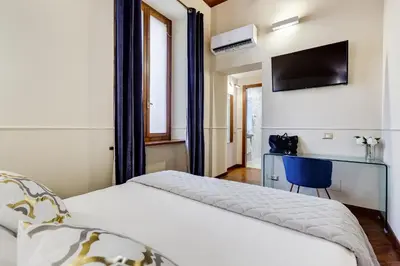 a bedroom with two beds and a tv on the wall at Trevi Private Suites by Premium Suites Collection in Rome