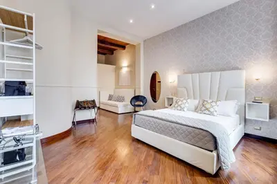 a bedroom with a large white bed and wooden floors at Trevi Private Suites by Premium Suites Collection in Rome