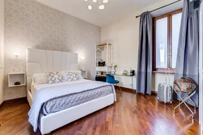 a bedroom with a large white bed and a wooden floor at Trevi Private Suites by Premium Suites Collection in Rome
