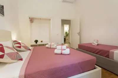 a bedroom with two beds with pink and white sheets at San Peter Dill House in Rome