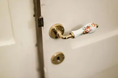 a gold door knob on a white door at Domus Titiana Amazing Apartment in Trastevere in Rome