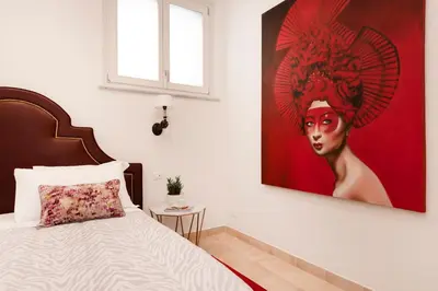 a bedroom with a painting of a woman on the wall at Divo Apartments - Spanish Steps in Rome