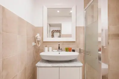 a bathroom with a sink and a mirror at Divo Apartments - Spanish Steps in Rome
