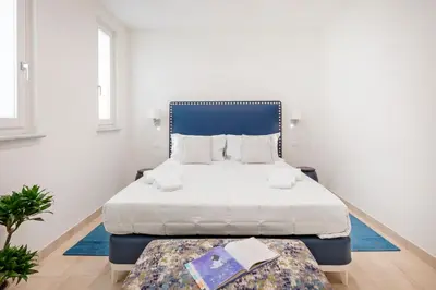 a bedroom with two beds and a blue headboard at Divo Apartments - Spanish Steps in Rome