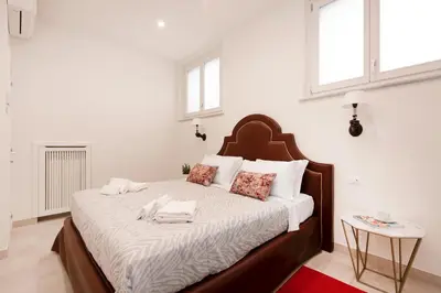 a bedroom with a large bed with white sheets and pillows at Divo Apartments - Spanish Steps in Rome