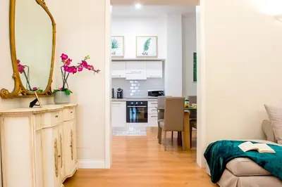 a living room with a mirror and a kitchen at SWEET DREAM CAVOUR in Rome