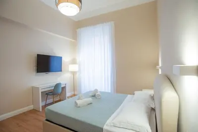a bedroom with a bed and a desk and a tv at SWEET DREAM CAVOUR in Rome