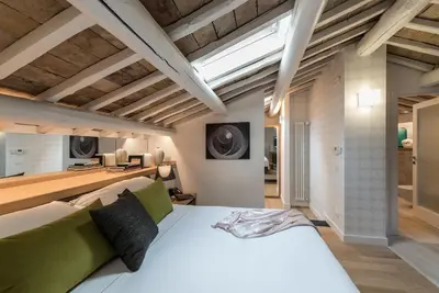 a bedroom with a large white bed and wooden ceilings at Laurina 33 in Rome