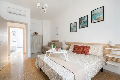 a white bedroom with a bed and a table at Stars Luxury Apartments 1 in Rome