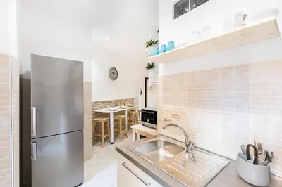 a kitchen with a stainless steel refrigerator and a table at Stars Luxury Apartments 1 in Rome