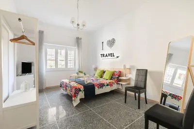 a bedroom with a bed and a chair and a mirror at Stars Luxury Apartments 1 in Rome