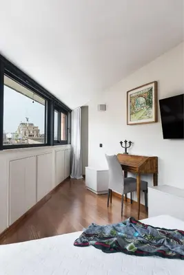 a bedroom with a desk and a window and a table at Idyllia - Penthouse in Navona Area in Rome