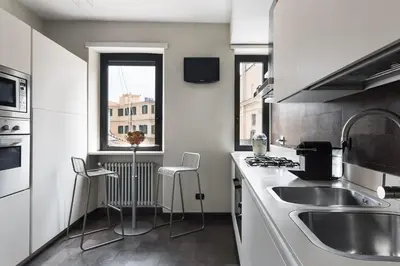 a kitchen with a sink and two chairs in it at Idyllia - Penthouse in Navona Area in Rome