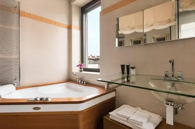 a bathroom with a tub and a glass sink at Idyllia - Penthouse in Navona Area in Rome