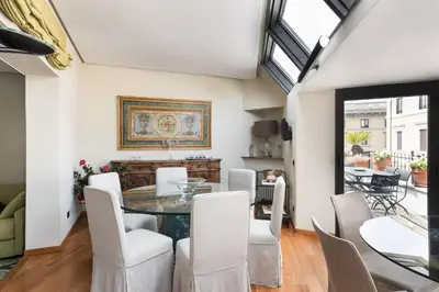 a dining room with a glass table and white chairs at Idyllia - Penthouse in Navona Area in Rome
