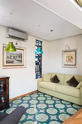 a living room with a couch and a rug at Idyllia - Penthouse in Navona Area in Rome