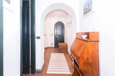 a hallway with a wooden dresser and a black door at spacious apartment in the centre of Rome in Rome