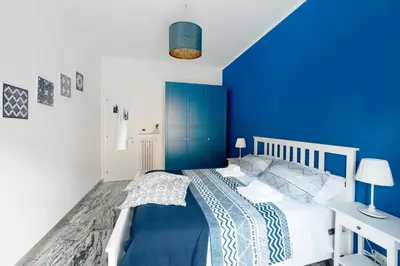 a blue bedroom with a white bed and a blue wall at Holiday Max in Rome