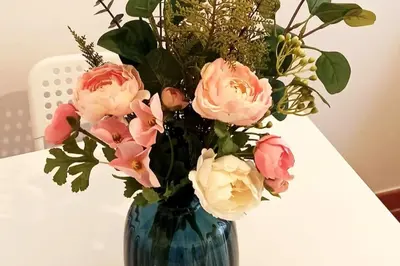 a blue vase filled with pink flowers on a table at St.Peter flat in Rome