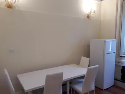 a kitchen with a white table and chairs and a refrigerator at AFFITTACAMERE ROMANSTYLE in Rome