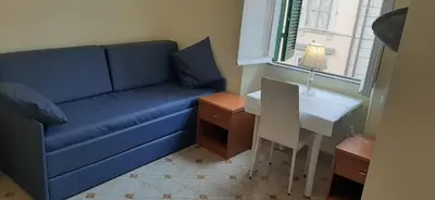 a living room with a blue couch and a table at AFFITTACAMERE ROMANSTYLE in Rome
