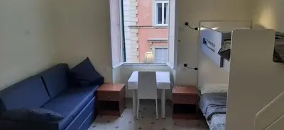 a small room with a blue couch and a table at AFFITTACAMERE ROMANSTYLE in Rome