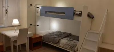 a room with a bunk bed with a desk and a tableablish at AFFITTACAMERE ROMANSTYLE in Rome
