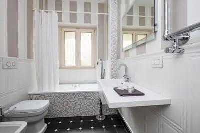 a white bathroom with a sink and a toilet at Vatican Quiet Apartment with Garden & Parking in Rome