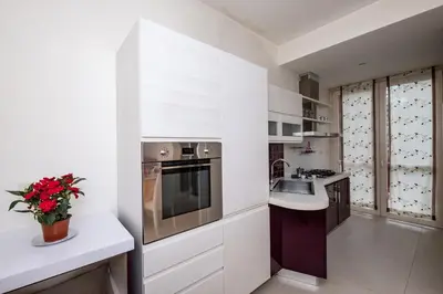 a kitchen with white cabinets and a sink at Vatican Quiet Apartment with Garden & Parking in Rome