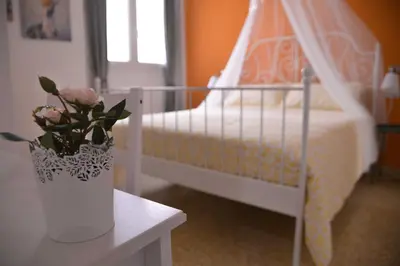 a bedroom with a bed and a vase with flowers on a table at Vatican Mirò Holidays in Rome